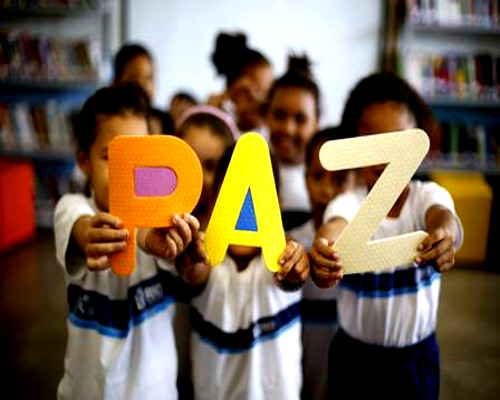 Foto de crianças segurando as letras da palavra paz