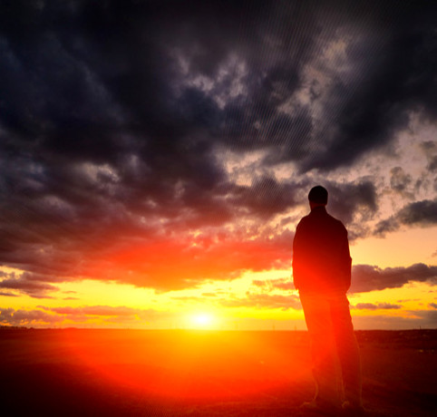 foto de homem observando paisagem de luz e trevas