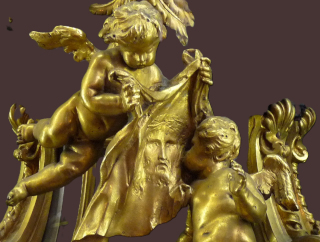 Escultura em tons dourados mostrando um anjo em voo carregando o sudário com o rosto de Jesus, beijado por outro anjo.